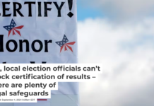 A sign at a rally as the Board of State Canvassers voted on Nov. 23, 2020, to certify the 2020 election in Okemos, Mich. Jeff Kowalsky/AFP/Getty Images